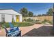 Landscaped backyard featuring a stone patio, Adirondack chairs, vibrant flowers, and a detached garage with a yellow door at 4883 Perry St, Denver, CO 80212
