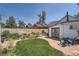 Relaxing backyard with stone patio, Adirondack chairs, lush landscaping, and a charming white garage at 4883 Perry St, Denver, CO 80212