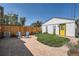 Private backyard with stone patio, Adirondack chairs, and a detached garage featuring a vibrant yellow door at 4883 Perry St, Denver, CO 80212