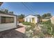 Picturesque backyard featuring a stone pathway, a detached garage with a yellow door, and beautiful flowerbeds at 4883 Perry St, Denver, CO 80212