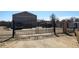 Property secured with a charming black metal gate, featuring wildlife artwork and leading to a spacious storage building at 15460 Casler Ave, Fort Lupton, CO 80136