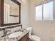 Bathroom featuring tile backsplash, sink, and toilet at 170 W Midway Blvd, Broomfield, CO 80020