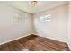 Bedroom featuring wood floors and two windows at 170 W Midway Blvd, Broomfield, CO 80020