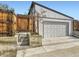 Detached garage with a gray door, adjacent to a wooden fence and steps leading to the yard at 170 W Midway Blvd, Broomfield, CO 80020