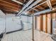Unfinished basement laundry room featuring a washer, dryer, white shelving, and tile flooring at 170 W Midway Blvd, Broomfield, CO 80020