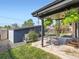 Outdoor patio area with table, chairs, hanging plants, a shed, and a view of the backyard at 170 W Midway Blvd, Broomfield, CO 80020