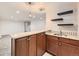 Finished basement wet bar featuring granite countertop, dark wood cabinetry, and modern pendant lighting at 170 W Midway Blvd, Broomfield, CO 80020