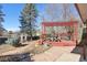 Backyard features a red pergola, landscaped yard and stone patio at 1755 S Yampa Way, Aurora, CO 80017