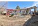 Backyard view with a red pergola, small deck, and landscaped ground at 1755 S Yampa Way, Aurora, CO 80017