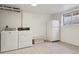 Basement laundry area with updated washer, dryer, and white refrigerator at 1755 S Yampa Way, Aurora, CO 80017