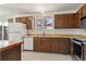 Cozy kitchen with wood cabinets, tile flooring, and a window overlooking the backyard at 1755 S Yampa Way, Aurora, CO 80017