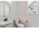 Simple bathroom with pedestal sink, toilet, and oval mirror at 17751 E 93Rd Ave, Commerce City, CO 80022