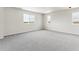 Bright bedroom featuring three windows and grey wall-to-wall carpet at 17751 E 93Rd Ave, Commerce City, CO 80022