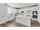 Modern kitchen with white cabinets, island, and stainless steel appliances at 17751 E 93Rd Ave, Commerce City, CO 80022