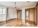 Bright bedroom features hardwood floors, closet with mirrored doors, and a unique chandelier at 8060 Meade St, Westminster, CO 80031