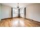 Spacious bedroom with hardwood floors, large windows, decorative curtains, and a vintage chandelier at 8060 Meade St, Westminster, CO 80031