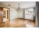 Spacious bedroom with hardwood floors, large windows, decorative curtains, and a vintage chandelier at 8060 Meade St, Westminster, CO 80031