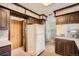 The kitchen and dining area with classic white refrigerator, wood cabinetry, and bright lighting at 8060 Meade St, Westminster, CO 80031