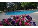 Inviting outdoor pool area with blooming flowers in the foreground and lounge chairs in the background at 13661 E Marina Dr # 406, Aurora, CO 80014