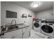 Well-lit laundry room features granite counters, updated appliances, and decorative wall accents at 6271 Mcintyre Way, Golden, CO 80403