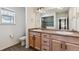 Bright bathroom with double vanity sinks, a tile-surround shower, and a window at 1160 Acadia Cir, Erie, CO 80516