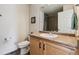 Bathroom with a vanity sink, toilet, and shower with tile surround at 1160 Acadia Cir, Erie, CO 80516