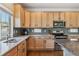 Well-lit kitchen features natural wood cabinets, modern appliances, and gray backsplash at 1160 Acadia Cir, Erie, CO 80516