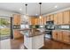 Open kitchen with a large center island, natural wood cabinets, and stainless steel appliances at 1160 Acadia Cir, Erie, CO 80516