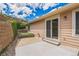 Inviting backyard patio with sliding glass doors, landscaped retaining wall, and access to the home's exterior at 119 Lake Ave, Palmer Lake, CO 80133