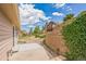 Spacious backyard patio featuring a retaining wall, rock landscaping, and serene views of surrounding homes and fence at 119 Lake Ave, Palmer Lake, CO 80133