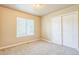 Neutral colored bedroom features carpet, closet, and large window at 119 Lake Ave, Palmer Lake, CO 80133