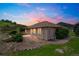 Exterior view of home with manicured landscaping, cozy patio, and beautiful sunset views in the evening at 119 Lake Ave, Palmer Lake, CO 80133