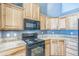Open space with wood cabinets, tile floors and view to a living room with fireplace at 119 Lake Ave, Palmer Lake, CO 80133