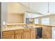 Bright kitchen with wood cabinets, stainless steel sink, neutral countertops, and tiled backsplash at 119 Lake Ave, Palmer Lake, CO 80133