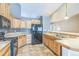 Kitchen with light wood cabinets, appliances and tile flooring at 119 Lake Ave, Palmer Lake, CO 80133