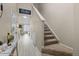 Inviting foyer with wood-look flooring and a carpeted staircase leading upstairs at 2005 E 103Rd Ave, Thornton, CO 80229