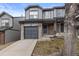 Attractive gray townhouse with a front entrance, garage, and stone accents at 2005 E 103Rd Ave, Thornton, CO 80229