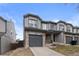 Charming gray two-story townhouse featuring a one-car garage and stone accents at 2005 E 103Rd Ave, Thornton, CO 80229