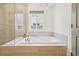Luxurious bathroom with a soaking tub, tile surround, and window with exterior view at 6281 Mcintyre Way, Golden, CO 80403