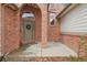Close-up of the brick front with an arched entry and frosted front door at 6281 Mcintyre Way, Golden, CO 80403
