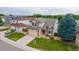Aerial view of two-story home with mature trees, front yard, and two car garage at 5075 Weeping Willow Cir, Highlands Ranch, CO 80130