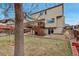Inviting backyard featuring a spacious lawn, elevated deck, and mature trees at 5075 Weeping Willow Cir, Highlands Ranch, CO 80130