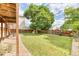 Large backyard with a wooden fence, mature tree, and lush green lawn at 5075 Weeping Willow Cir, Highlands Ranch, CO 80130