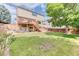Lush backyard with a wooden deck, patio area and expansive green lawn at 5075 Weeping Willow Cir, Highlands Ranch, CO 80130