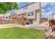 Well-maintained backyard with a wooden deck, patio and lush green lawn at 5075 Weeping Willow Cir, Highlands Ranch, CO 80130