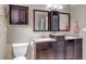 Well-lit bathroom featuring double sink vanity with granite countertops and dark wood cabinets at 5075 Weeping Willow Cir, Highlands Ranch, CO 80130