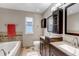 Bright bathroom featuring a soaking tub, double vanity with dark cabinets, and modern fixtures at 5075 Weeping Willow Cir, Highlands Ranch, CO 80130