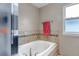 A tiled soaking tub beneath a bright window adds to the spa like quality at 5075 Weeping Willow Cir, Highlands Ranch, CO 80130