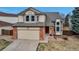 Charming two-story home with a brick-accented garage, bay window, and red front door at 5075 Weeping Willow Cir, Highlands Ranch, CO 80130