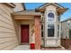 Welcoming entrance featuring a red door, brick accents, and stylish architectural details at 5075 Weeping Willow Cir, Highlands Ranch, CO 80130